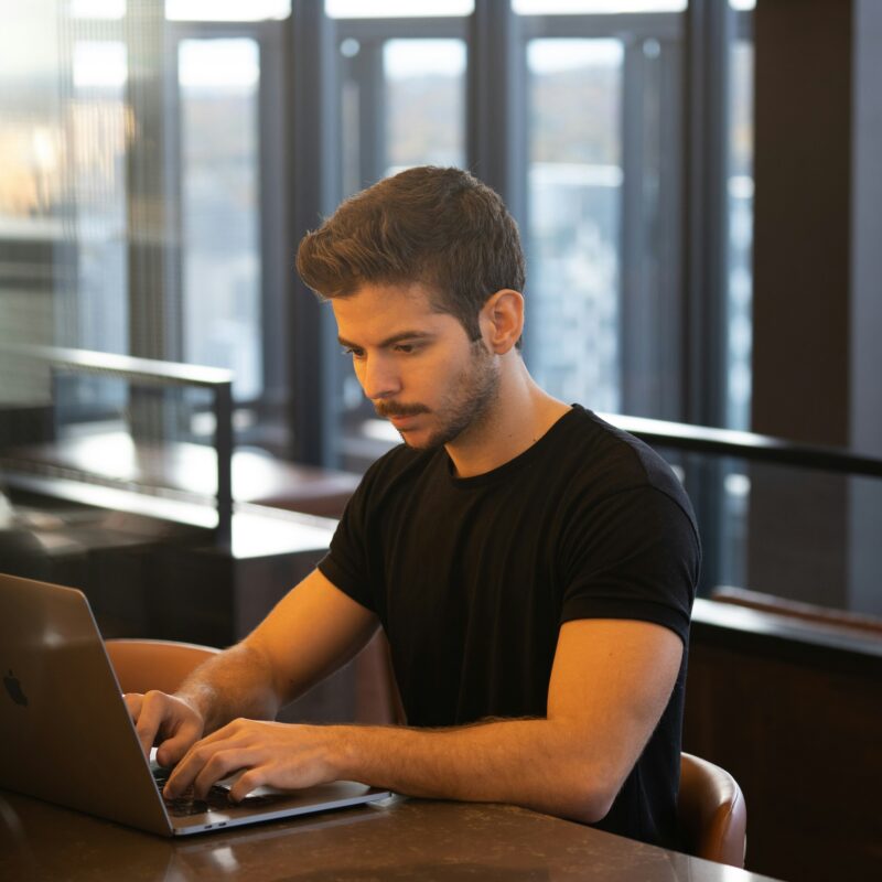A focused digital marketer works on a laptop in a modern office, implementing strategic internal linking to enhance website SEO and user navigation.