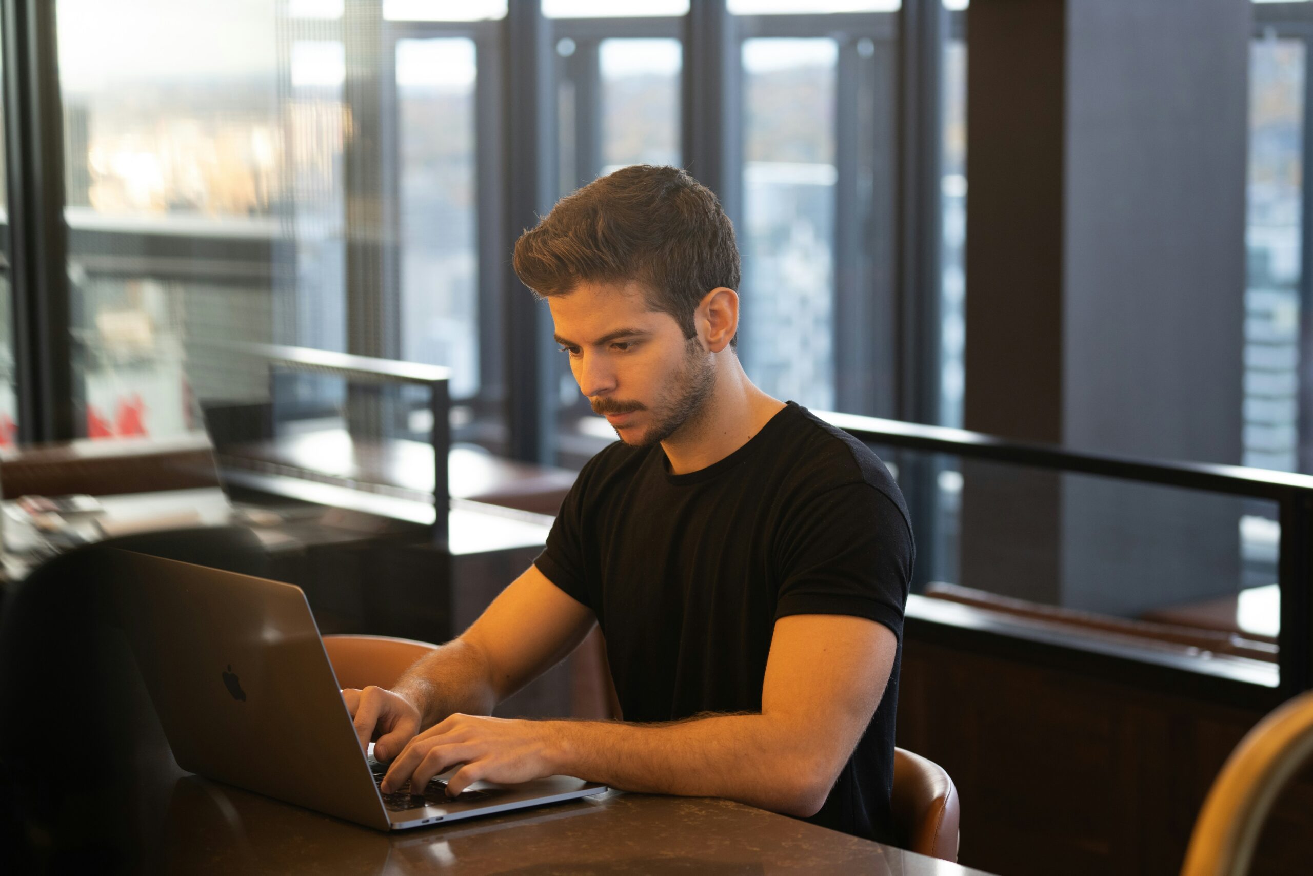 A focused digital marketer works on a laptop in a modern office, implementing strategic internal linking to enhance website SEO and user navigation.