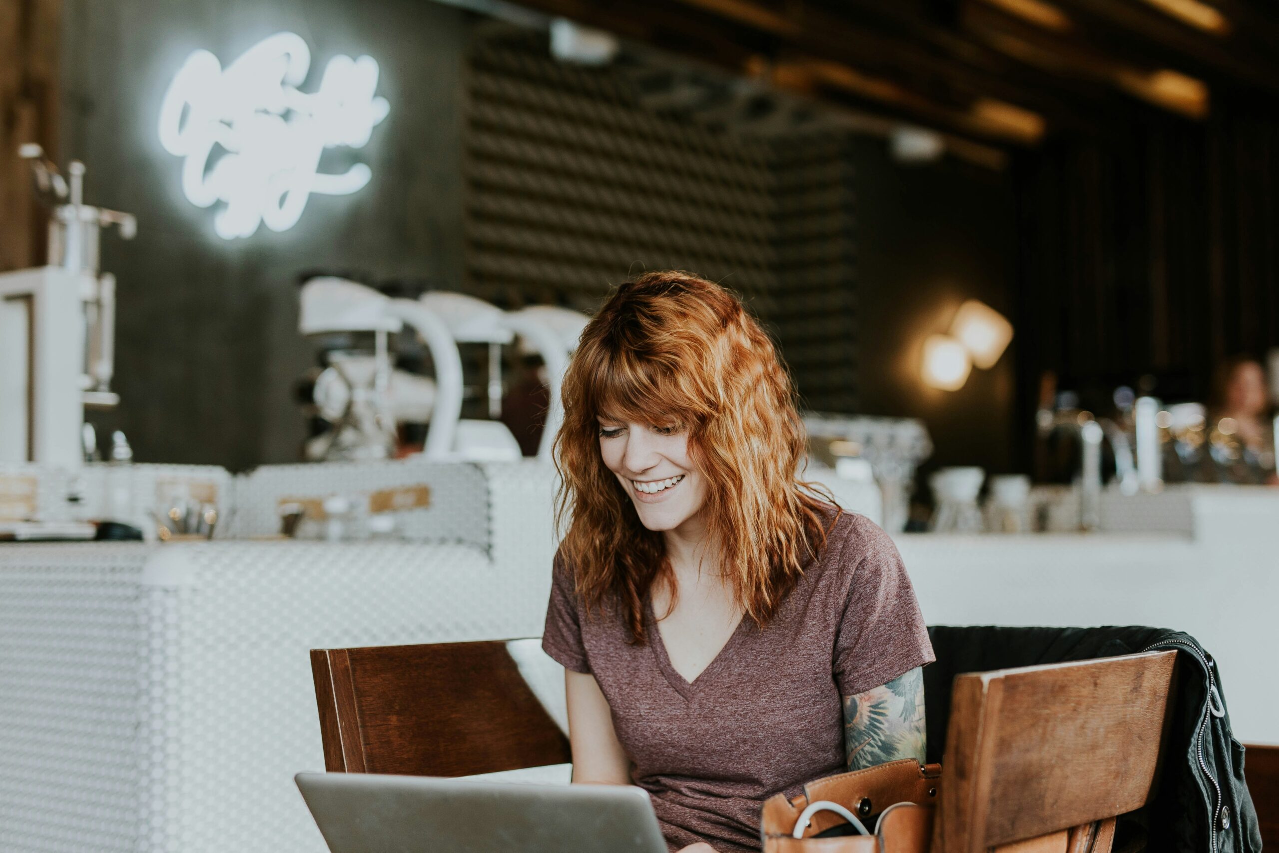 A person smiling while working on a laptop, symbolizing the ease of managing web design SEO services and the user-friendly tools they offer to optimize site performance.