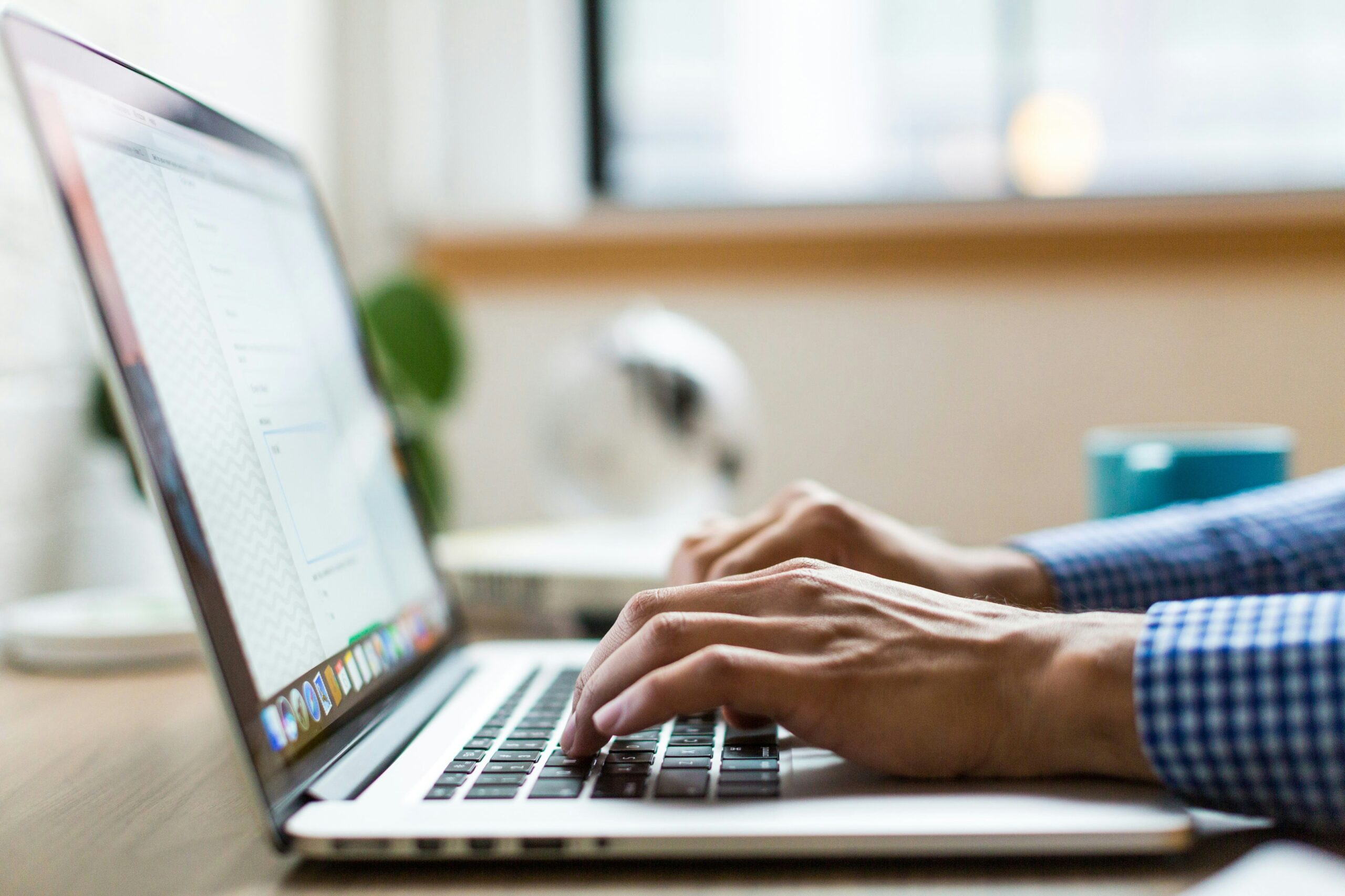 A person working on a laptop, showcasing the hands-on work of optimizing web content and design in the context of SEO to improve site rankings and traffic.