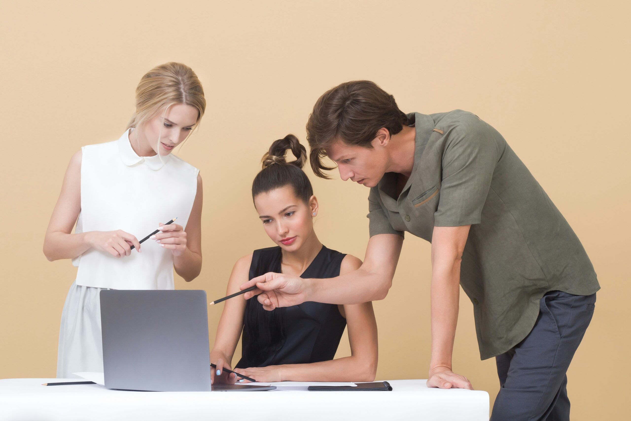 Three people collaborating on a project, illustrating the teamwork required to decide between local and national web design CMS platforms based on business requirements.