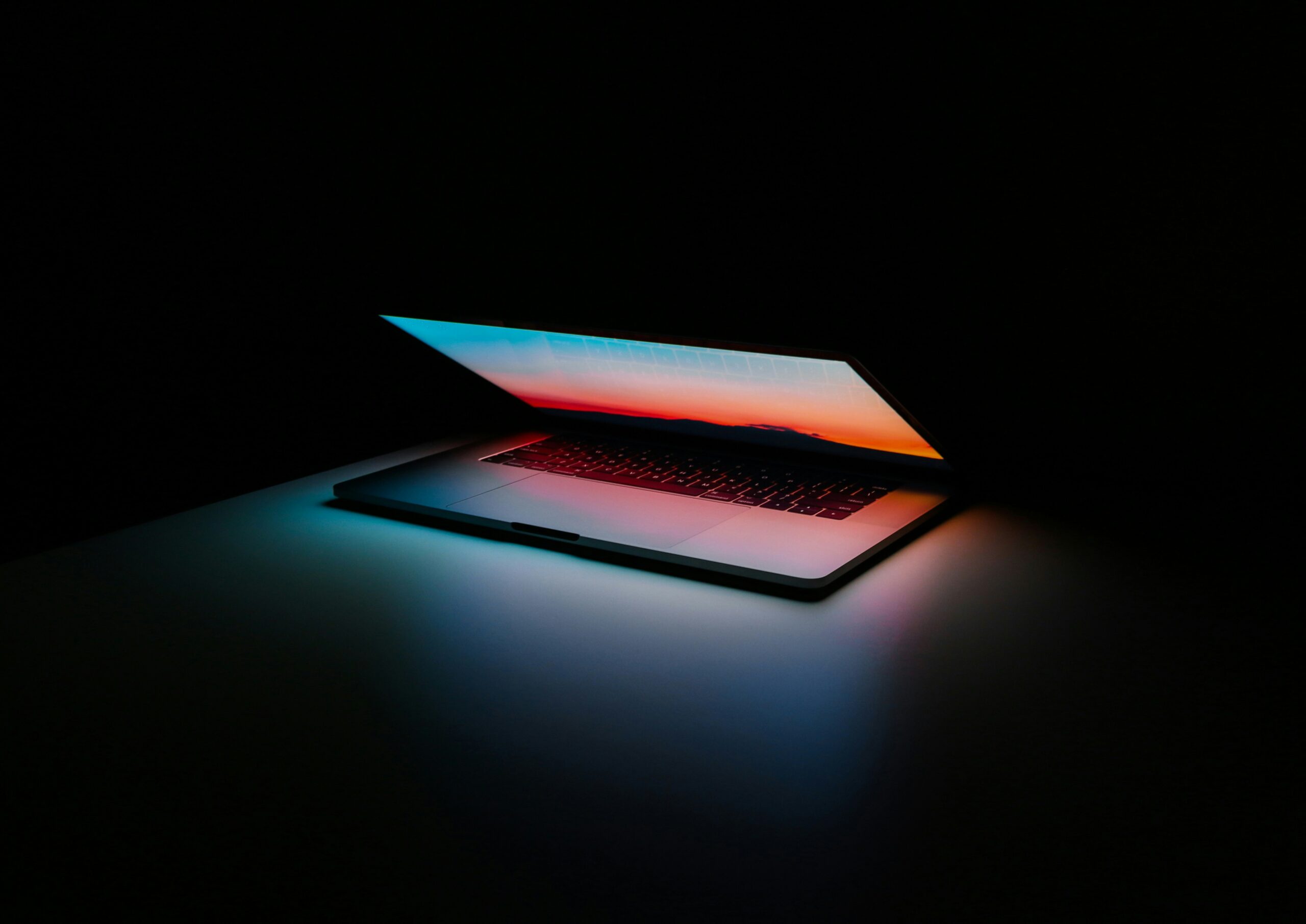 A laptop glowing in the dark, symbolizing the importance of understanding the technical aspects of local web design CMS providers and the solutions they offer for small businesses.