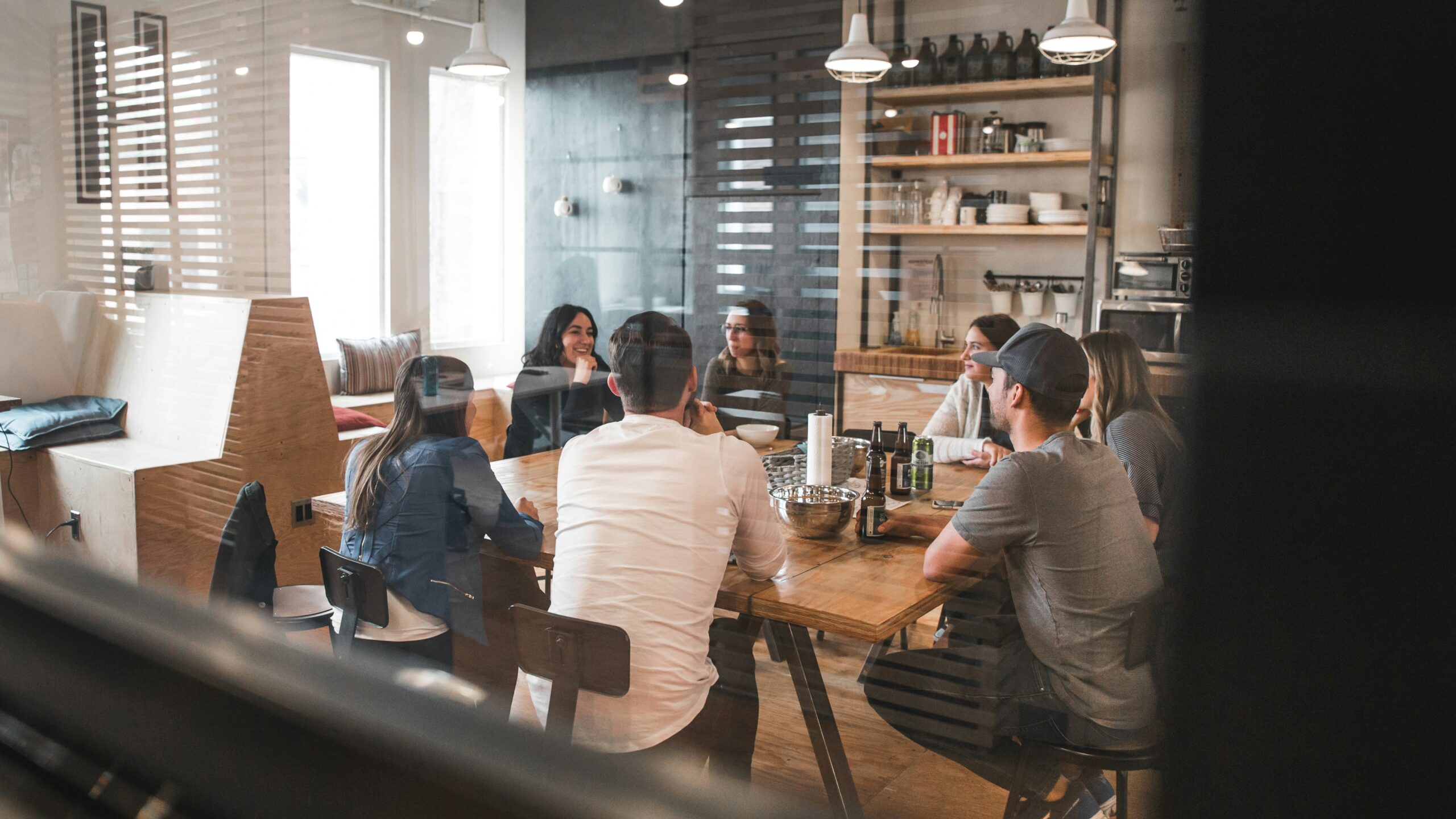 A group of people in a meeting room discussing, highlighting the need to evaluate support and community resources for a CMS to ensure reliable assistance and ongoing development.