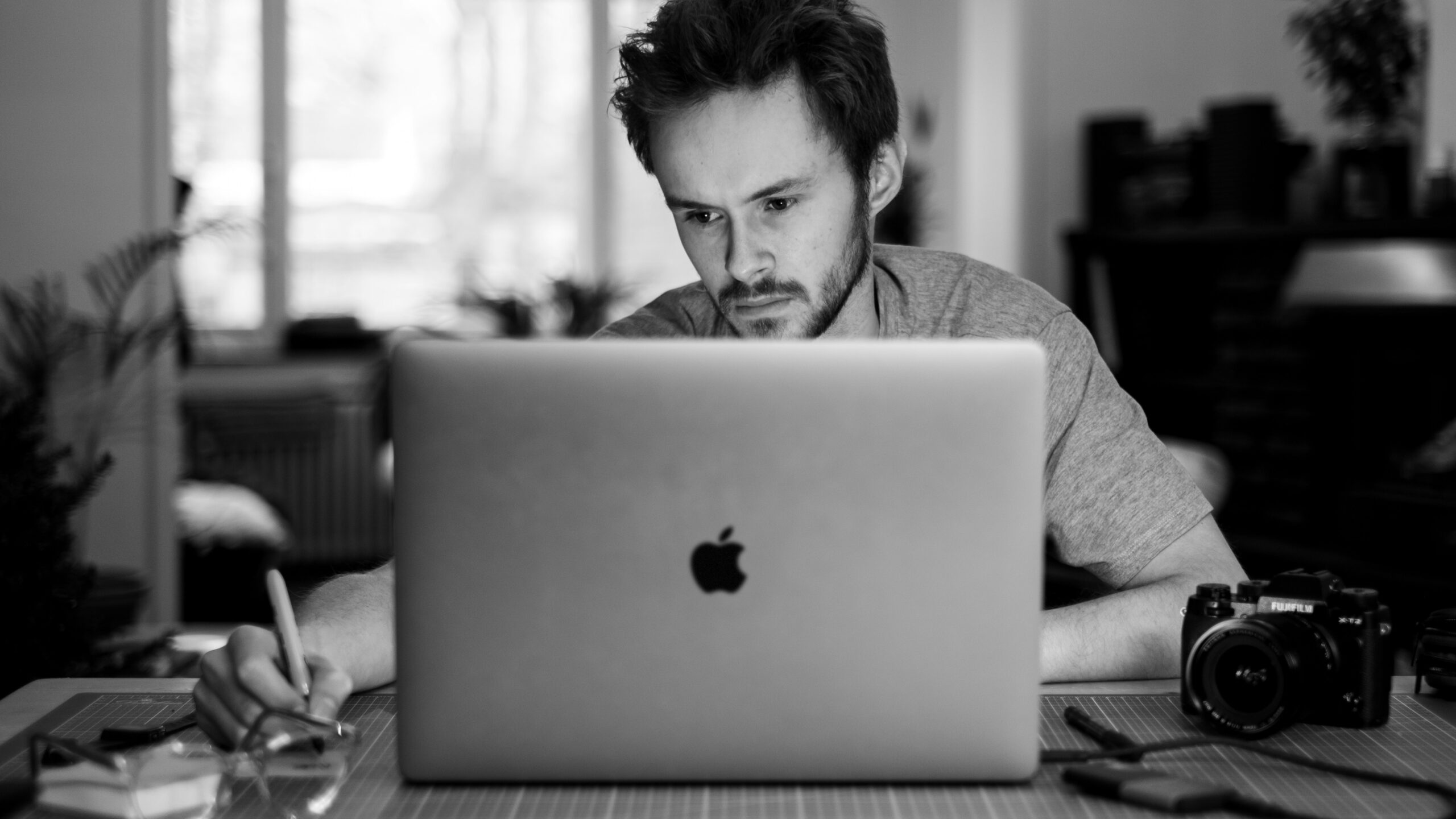 A person focused on a laptop, representing the in-depth consideration businesses need when evaluating a CMS for local vs national reach in web design.A person focused on a laptop, representing the in-depth consideration businesses need when evaluating a CMS for local vs national reach in web design.