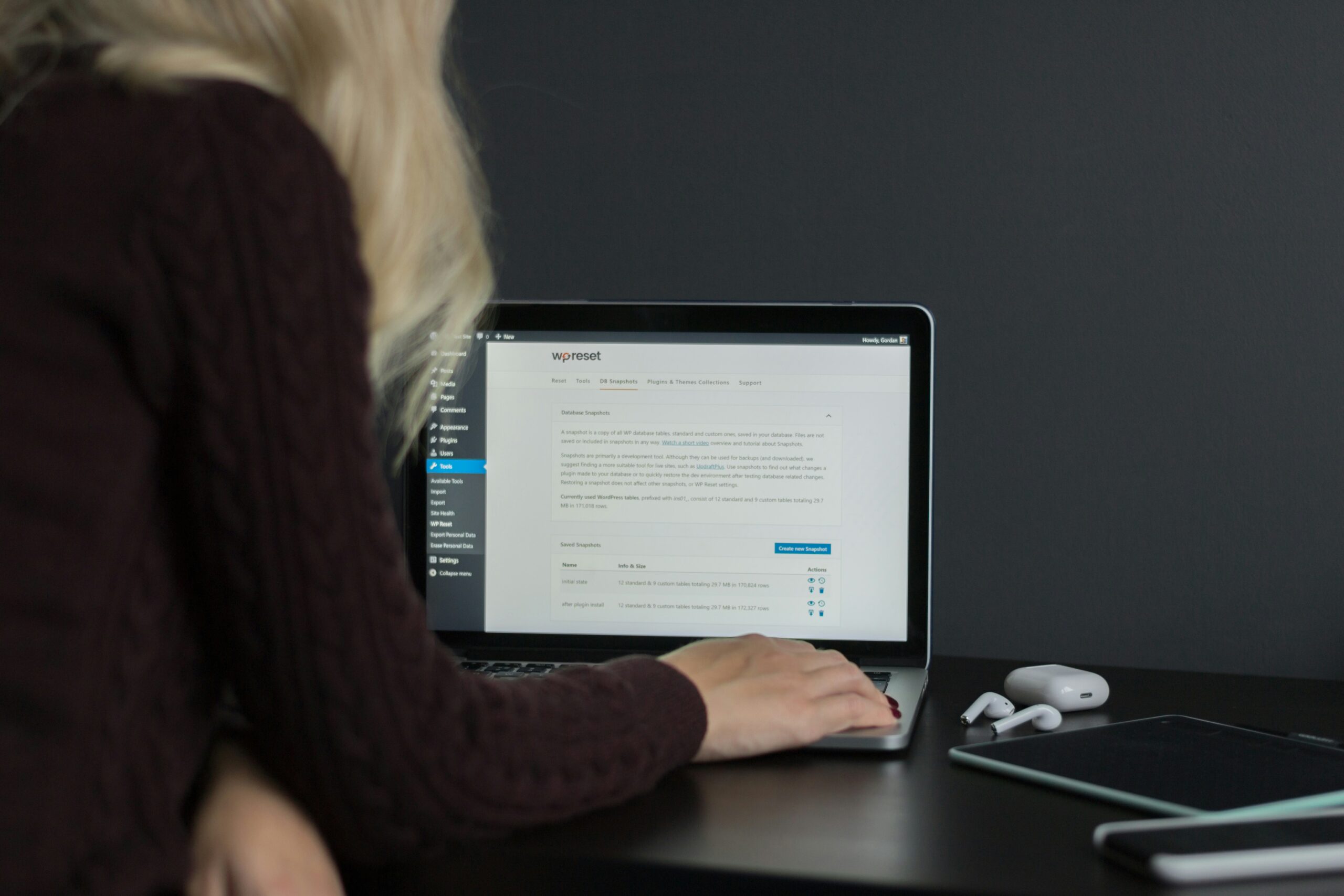 A woman using a laptop with a CMS dashboard open, providing an overview of top CMS platforms for effective website development and showcasing their user-friendly content management experience.