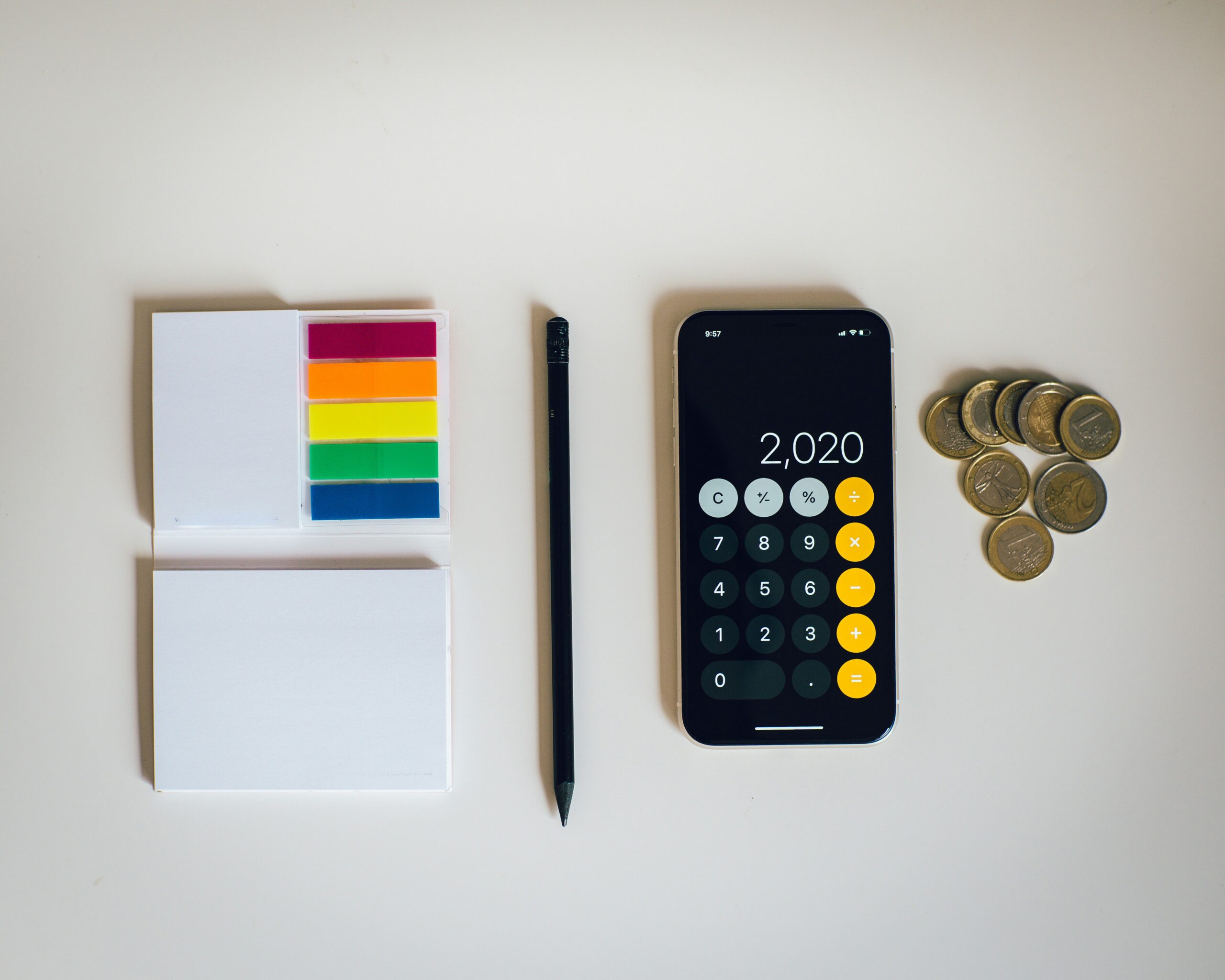 A minimalist workspace featuring a notepad, calculator, and coins, emphasizing CMS cost and budgeting considerations.