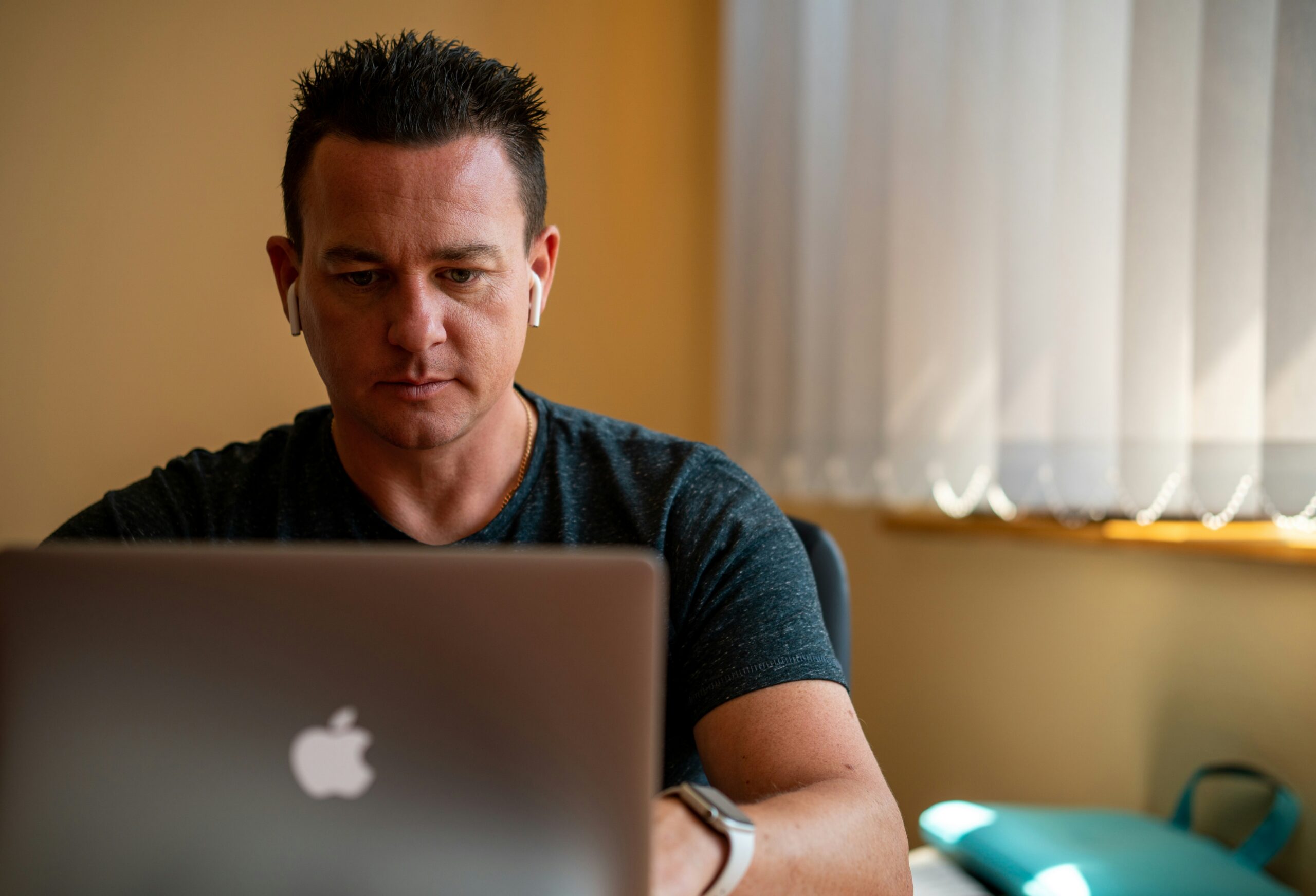 A man working on a laptop at a desk, highlighting the key features of tailored CMS development services, including usability, interface customization, and flexibility to meet specific business needs.