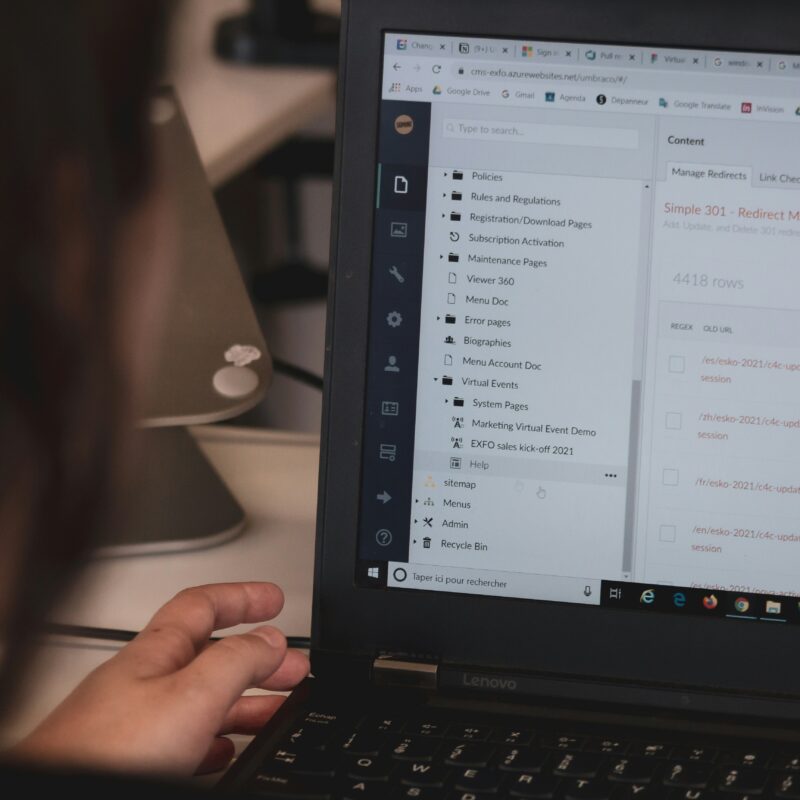 A person working on a laptop with a CMS dashboard open, representing the flexibility and control offered by open-source CMS platforms.