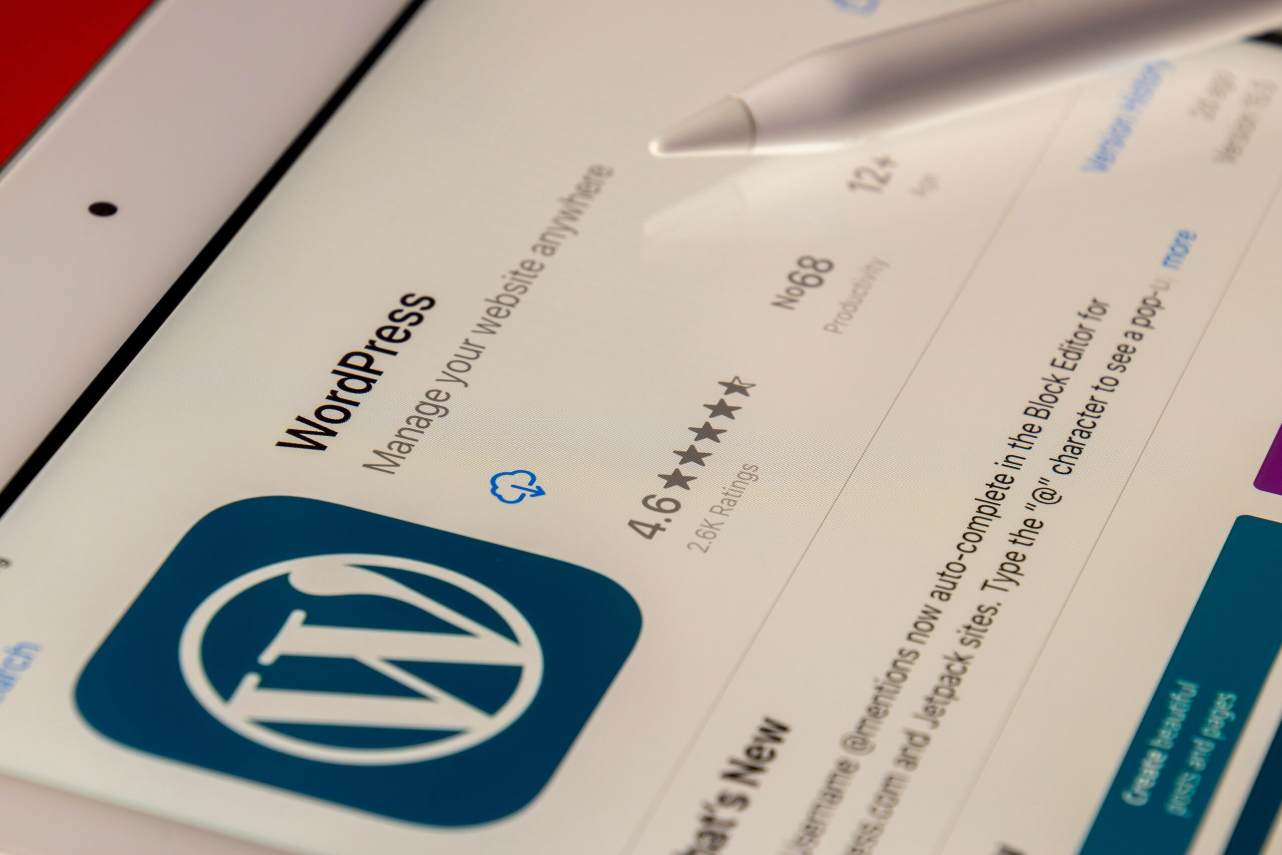 A close-up of a tablet screen showing the WordPress app, highlighting its 4.6-star rating and features related to managing websites, representing one of the top content management systems 