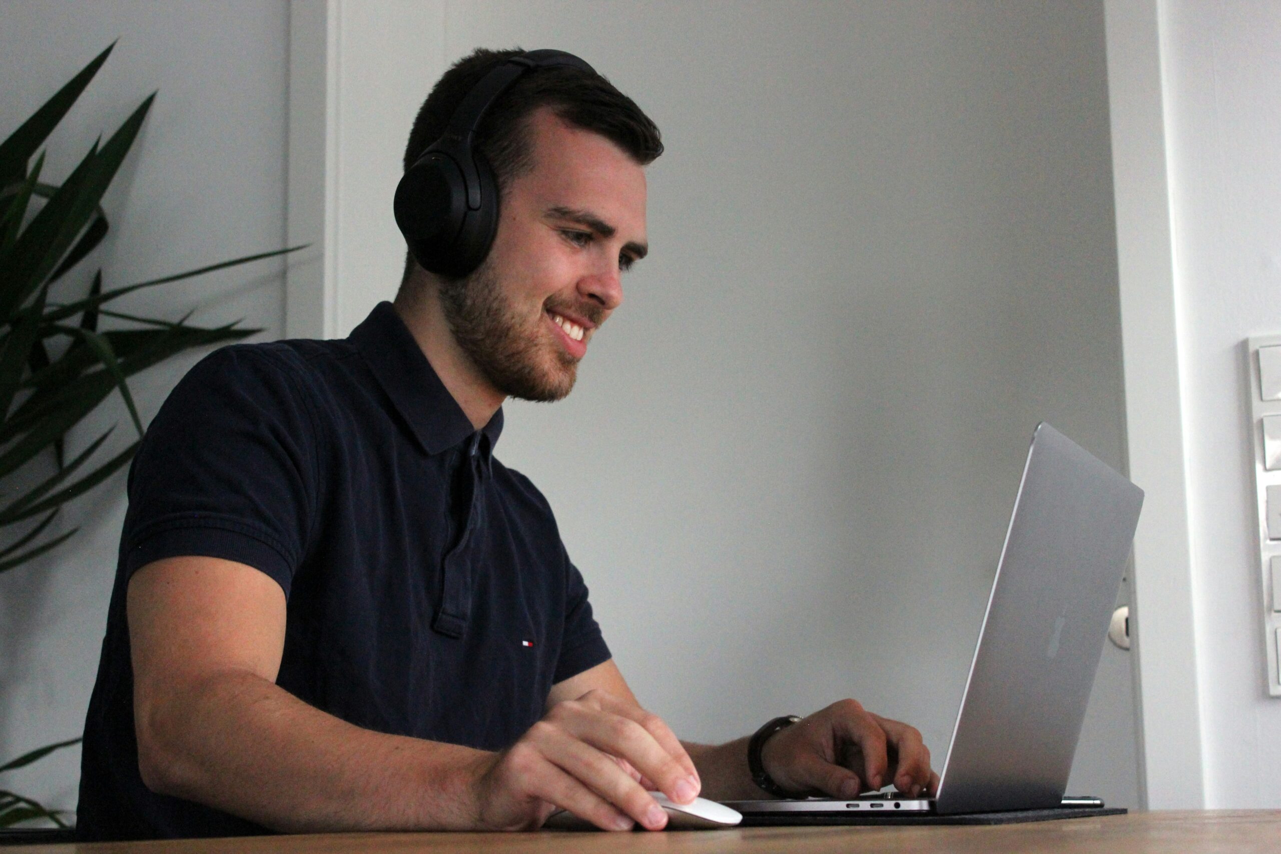 A man wearing headphones working on a laptop, representing the ease of content management with CMS platforms.