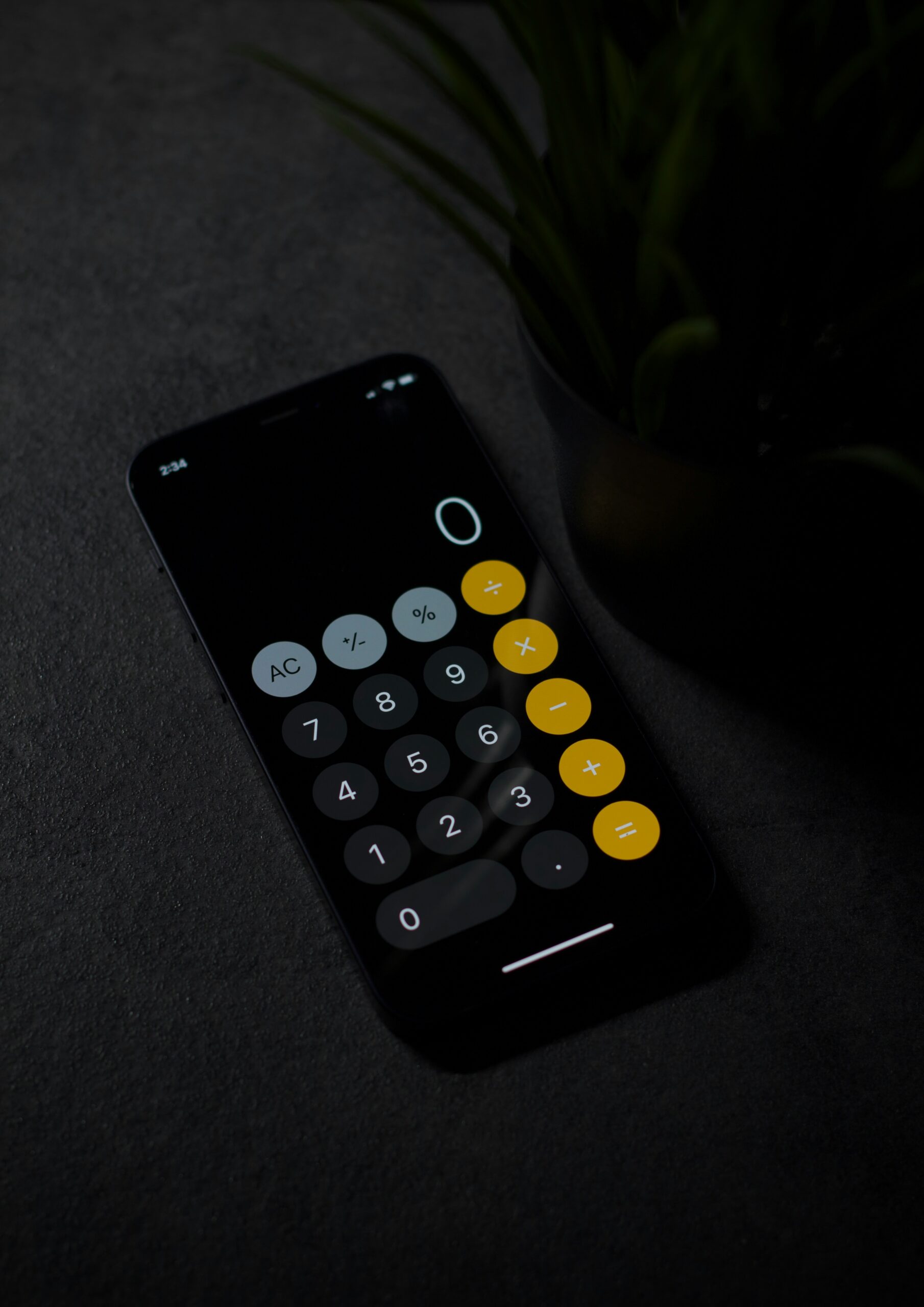 A smartphone calculator on a dark surface, emphasizing cost considerations when choosing between web design services and traditional CMS.