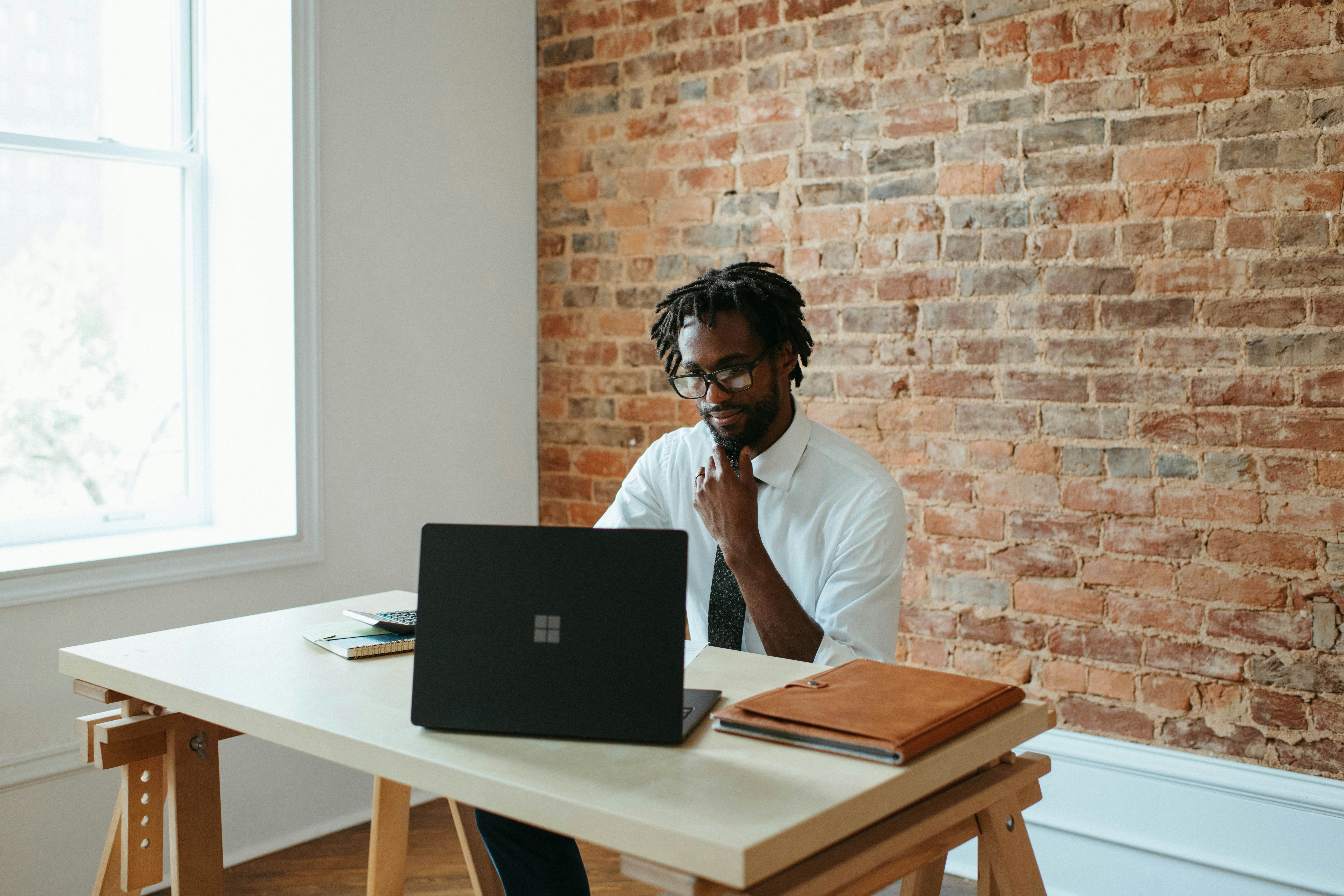 A man working on a laptop at a desk, representing the importance of evaluating usability and interface when selecting a CMS.