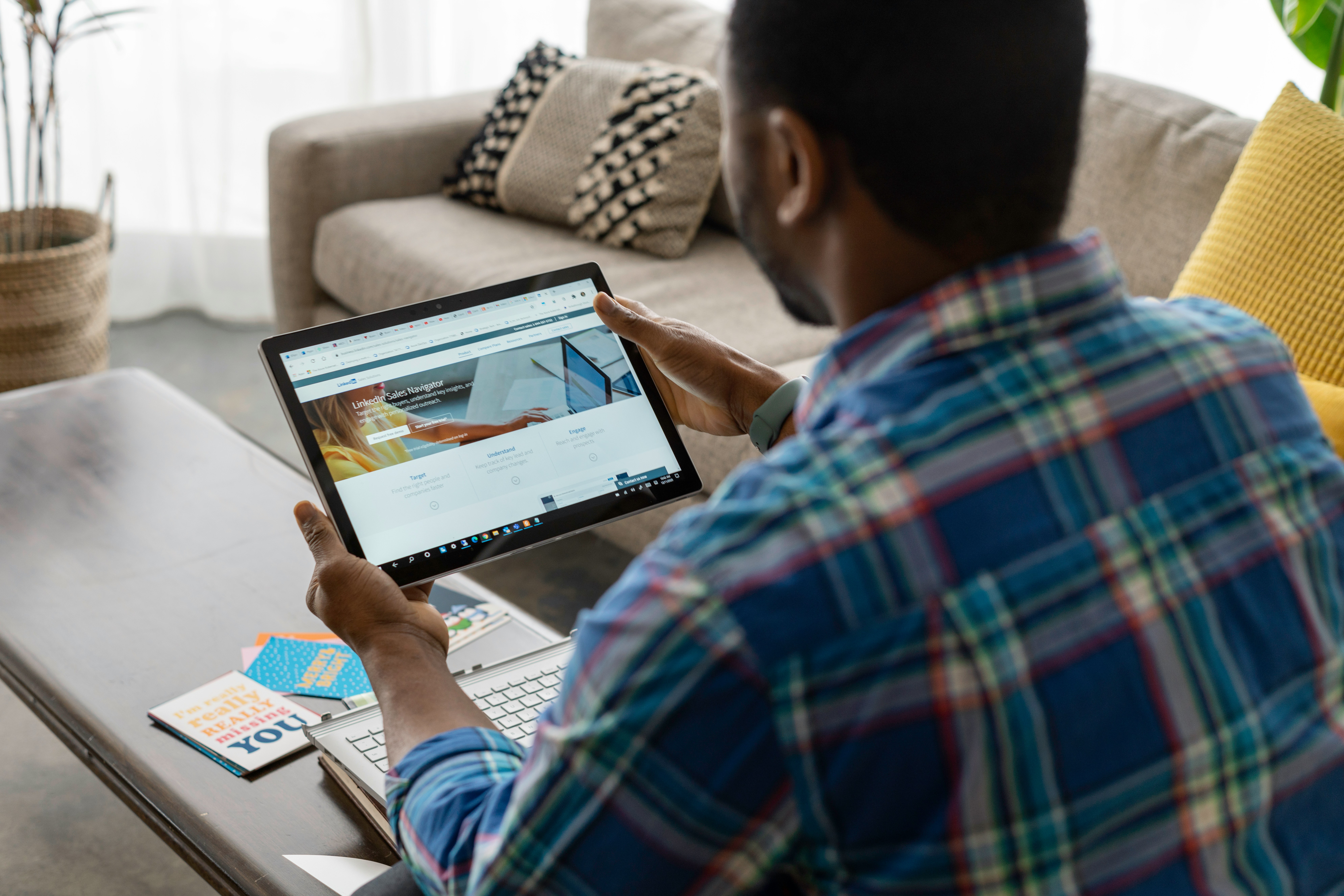 A person using a tablet to browse a website, illustrating how responsive design enhances user engagement across different devices.