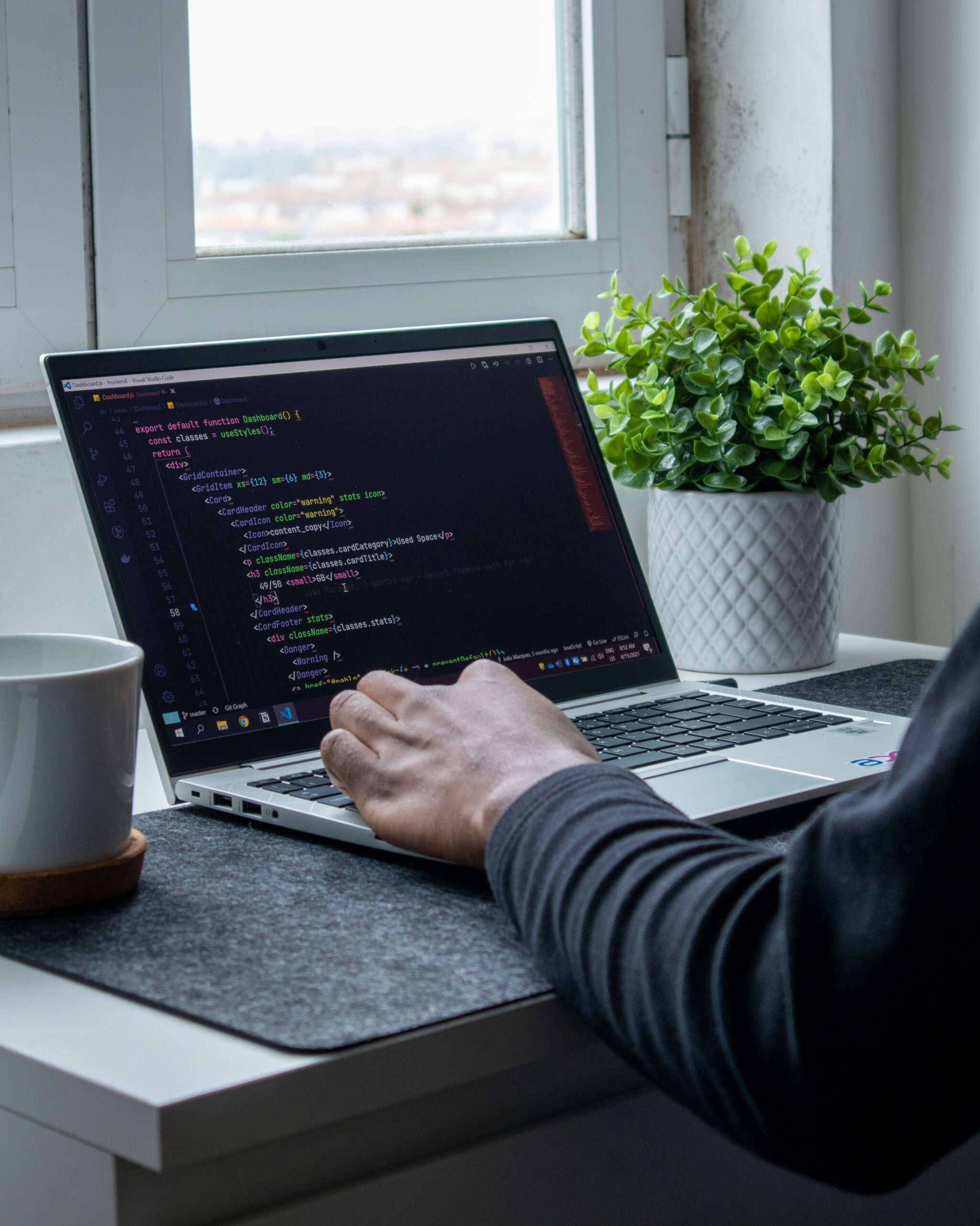 A developer working on a laptop with code displayed on the screen, showcasing front-end technologies we use to build modern web applications.