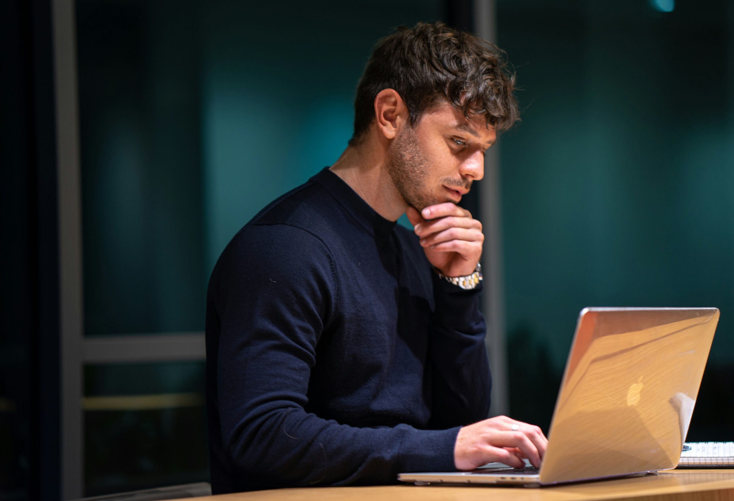 A focused professional analyzing options on a laptop, representing the decision-making process for choosing the right front-end technology for an app.