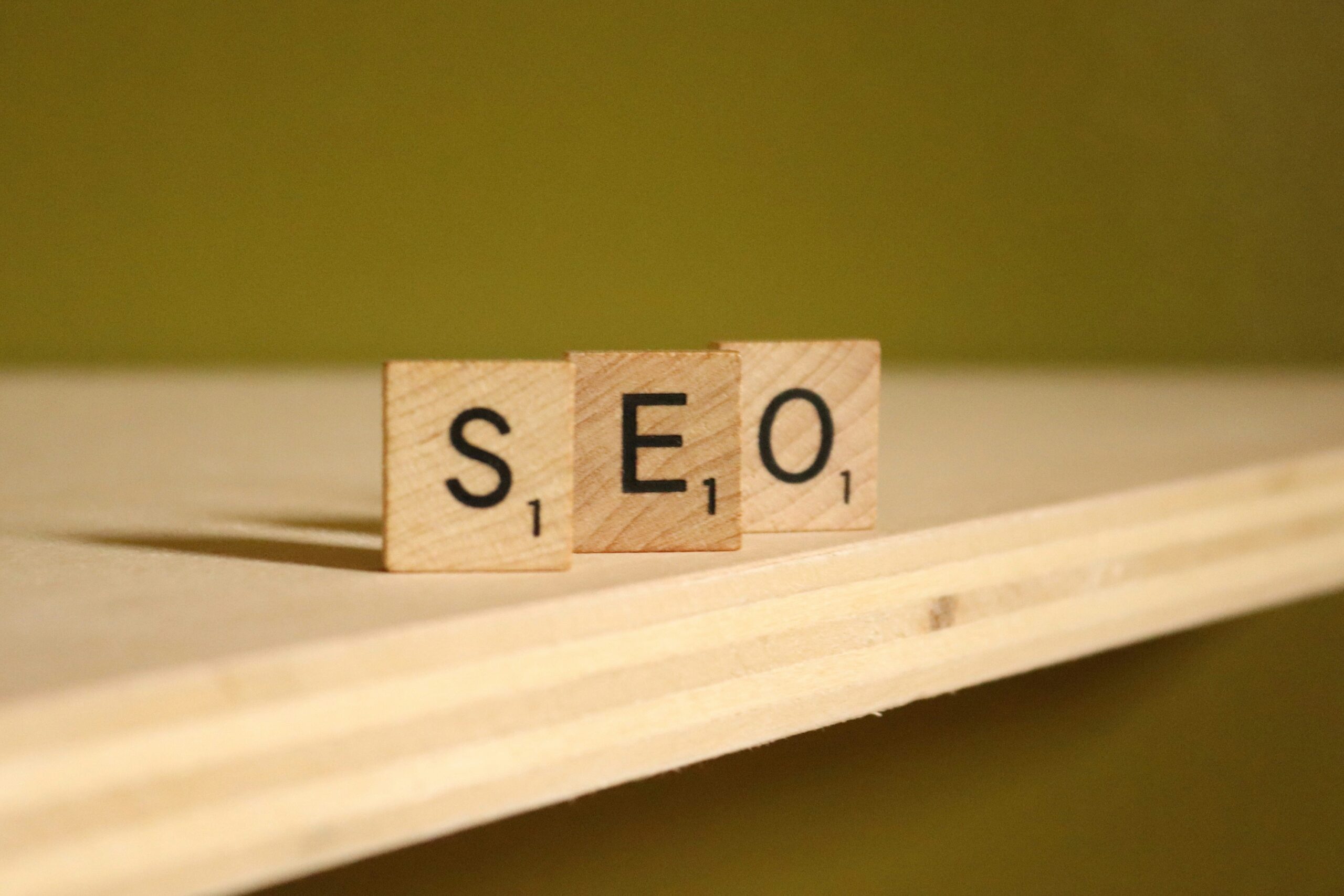 Three wooden Scrabble tiles spelling "SEO" sit on a light wood shelf—symbolizing the importance of monitoring search engine optimization performance for strategic, data-driven improvements. | Day by Day Digital Three wooden Scrabble tiles spelling "SEO" sit on a light wood shelf—symbolizing the importance of monitoring search engine optimization performance for strategic, data-driven improvements.