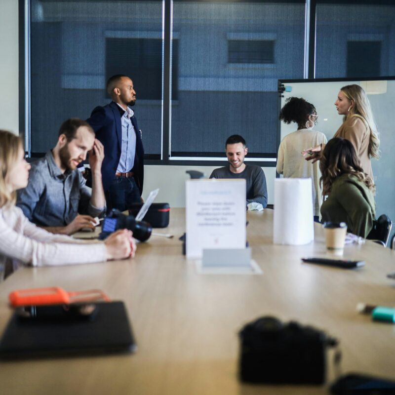 A group of people collaborating around a conference table, representing team planning for an effective SEO content strategy.