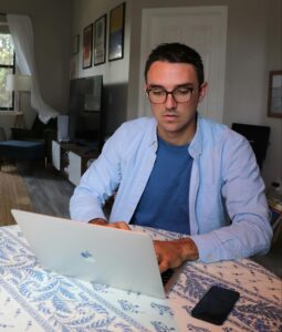 A man working on a laptop in a home office reflects the research and consideration behind common business questions about affordable SEO content writing.