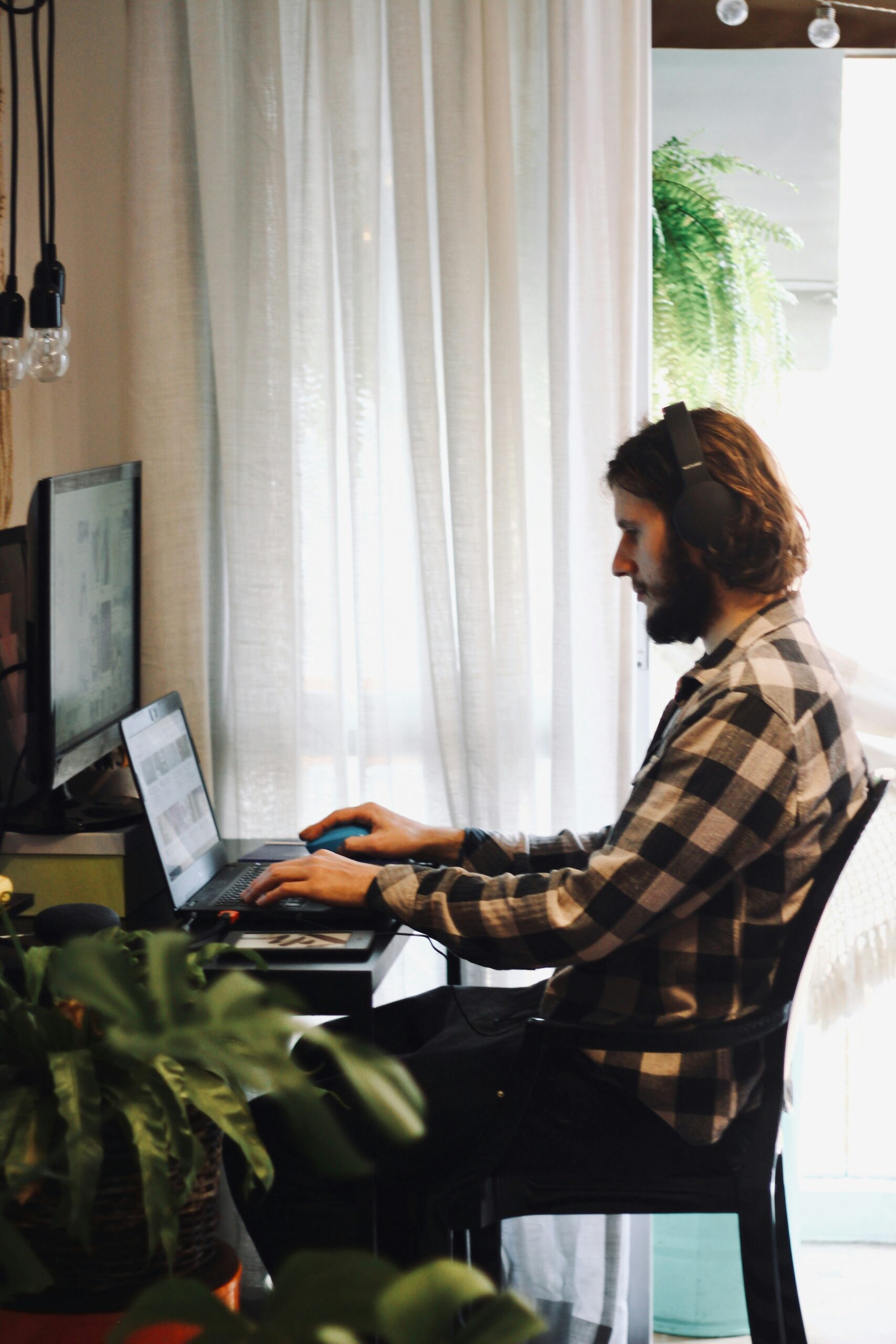 Man working on a laptop at home with dual monitors, focusing on optimizing product listings to improve organic traffic for an eCommerce site. | Day by Day Digital Man working on a laptop at home with dual monitors, focusing on optimizing product listings to improve organic traffic for an eCommerce site.