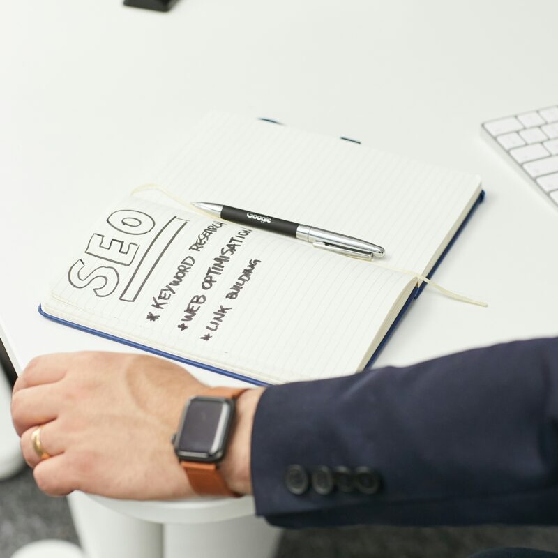 A notebook with SEO strategies like keyword research, web optimization, and link building, symbolizing on-page SEO and content structuring planning.