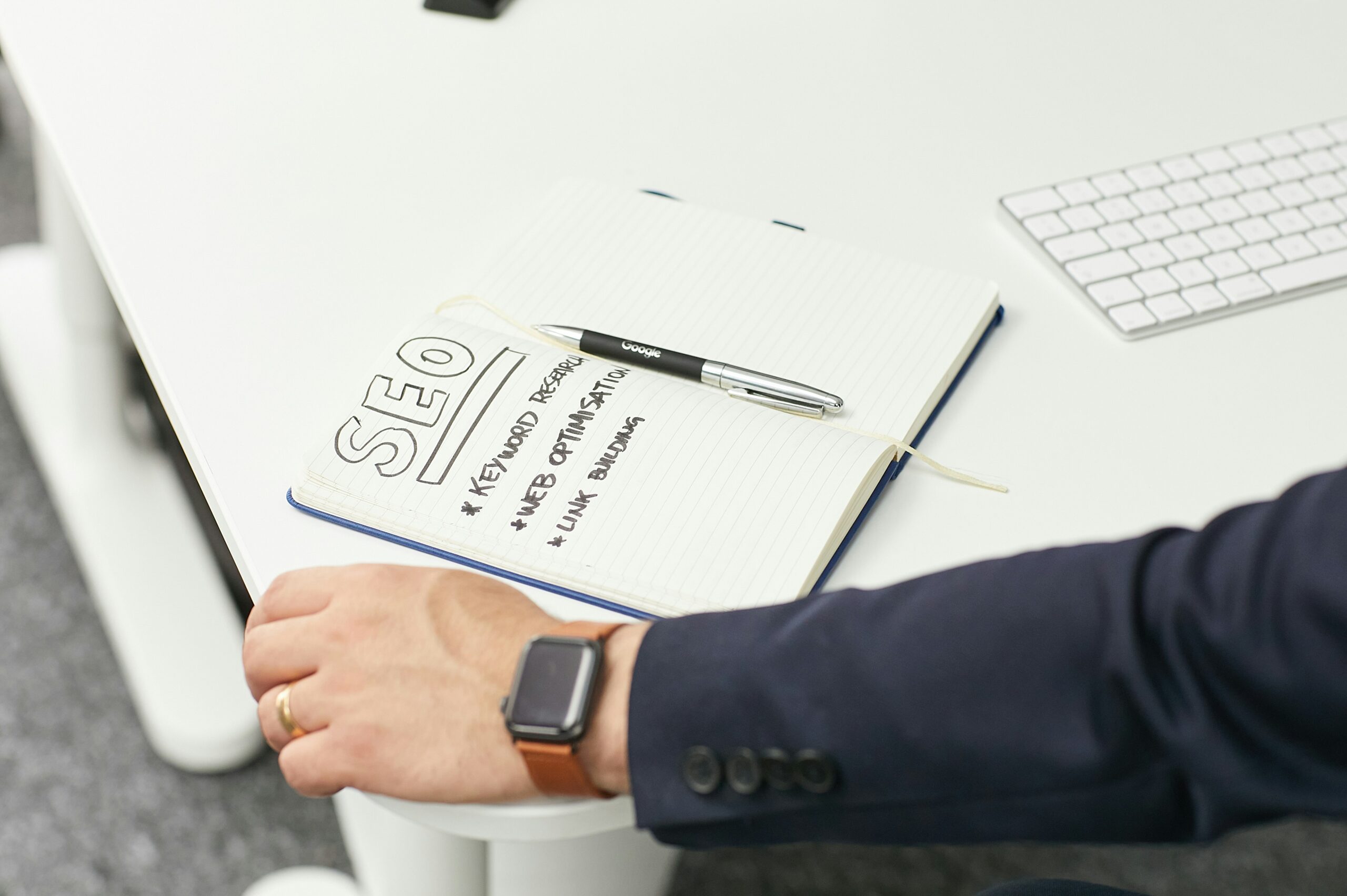 A notebook with SEO strategies like keyword research, web optimization, and link building, symbolizing on-page SEO and content structuring planning.