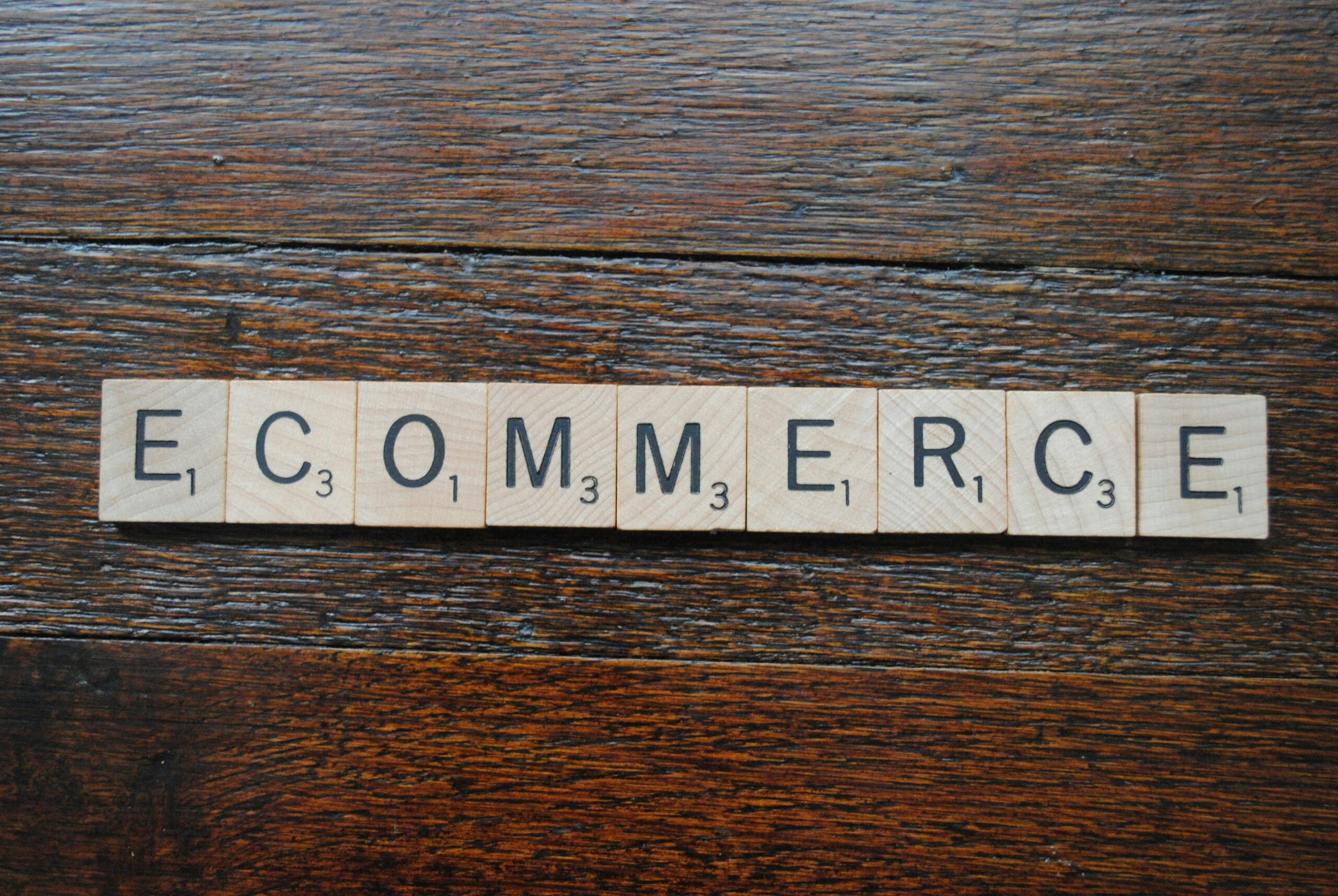 Wooden tiles spelling "ecommerce" laid out on a wooden surface, representing the strategic process of measuring and refining SEO performance for online stores. | Day by Day Digital Wooden tiles spelling "ecommerce" laid out on a wooden surface, representing the strategic process of measuring and refining SEO performance for online stores.