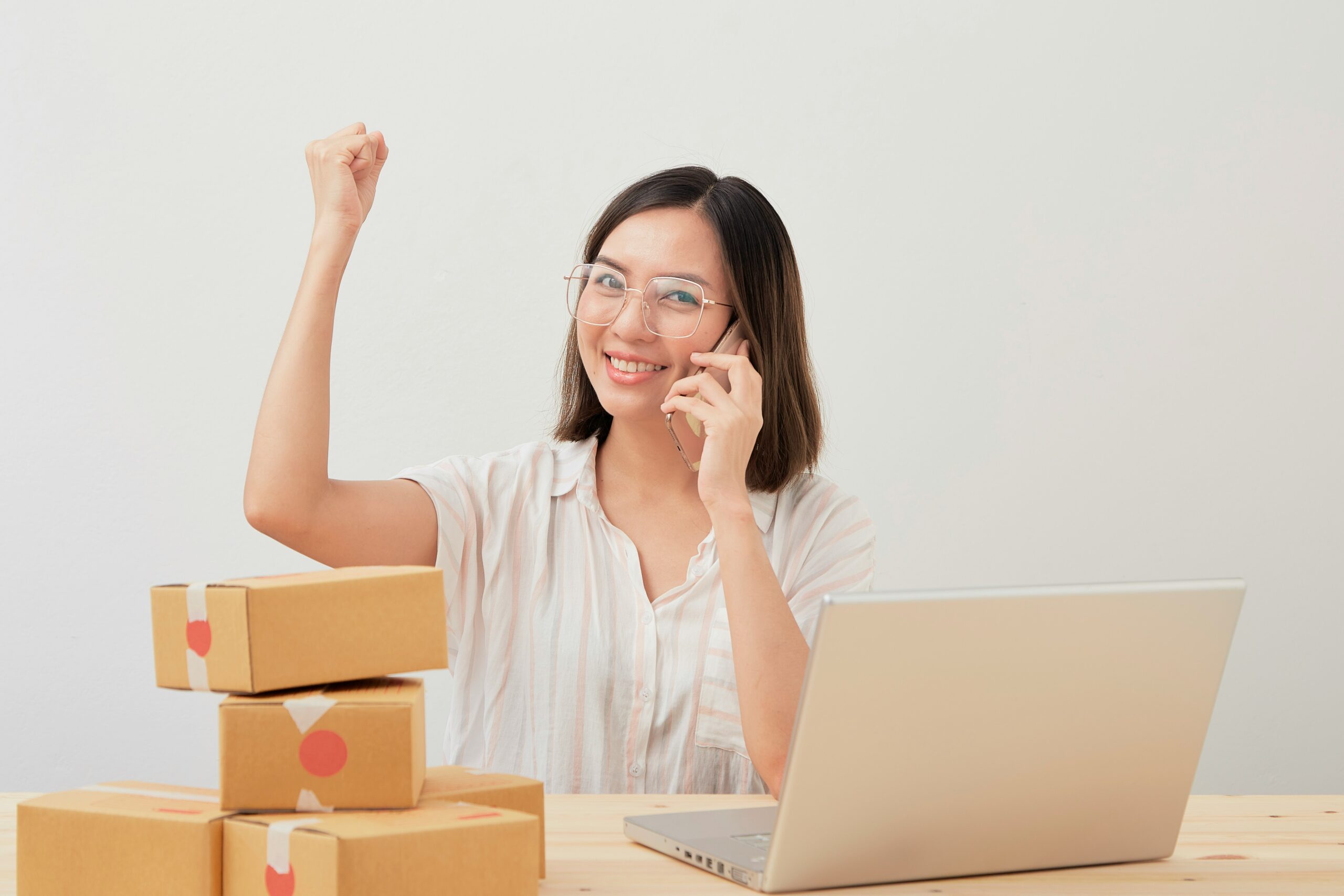 Excited online seller celebrating success while managing orders on a laptop, symbolizing the impact of applying advanced ecommerce SEO strategies. | Day by Day Digital Excited online seller celebrating success while managing orders on a laptop, symbolizing the impact of applying advanced ecommerce SEO strategies.