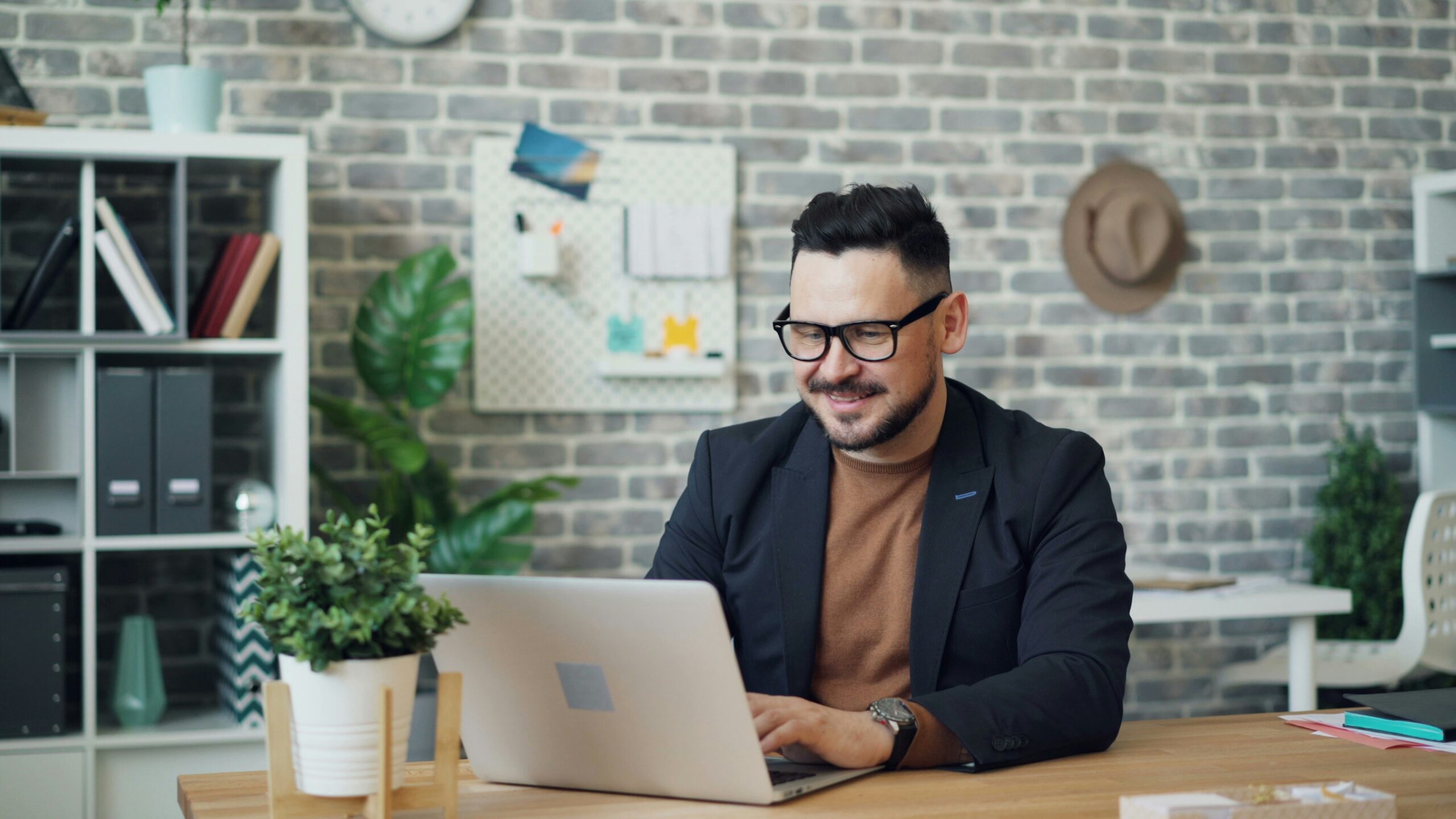 A man works confidently on his laptop in a modern office, reflecting the focus and precision required for implementing technical SEO strategies to optimize online store performance.