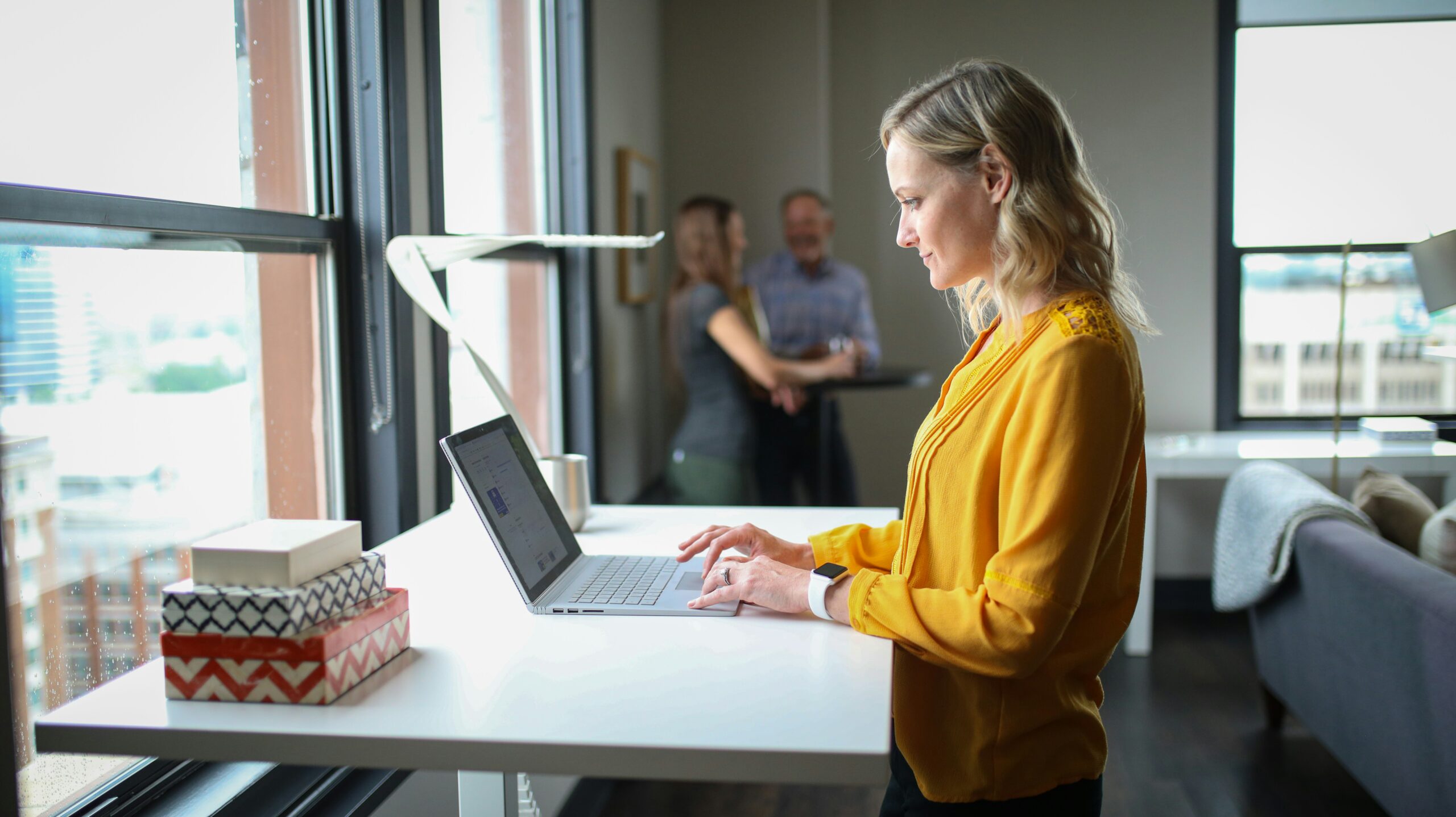 Woman working on a laptop by the window, representing focused research into effective white hat link building methods for long-term SEO success. | Day by Day Digital Woman working on a laptop by the window, representing focused research into effective white hat link building methods for long-term SEO success.