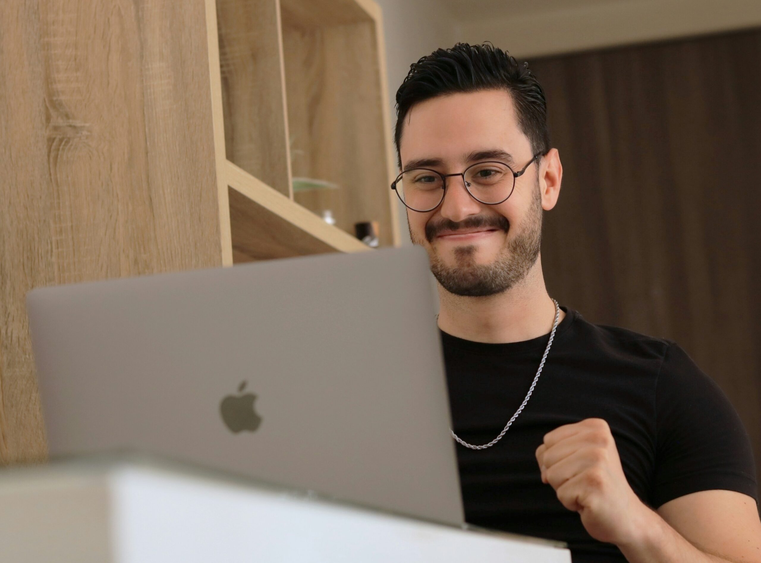 A smiling man celebrating while working on a laptop, representing success after implementing a technical SEO audit's recommendations. | Day by Day Digital A smiling man celebrating while working on a laptop, representing success after implementing a technical SEO audit's recommendations.